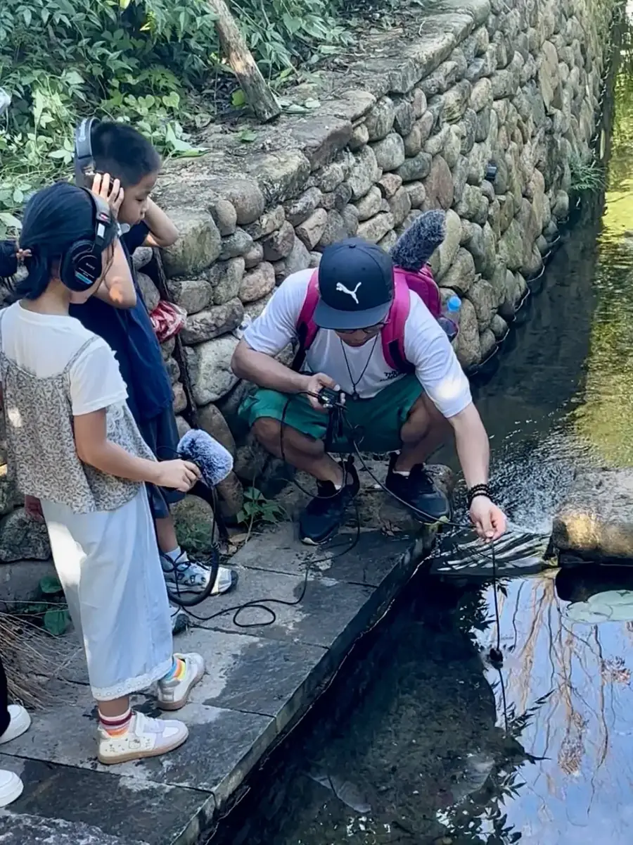 孩子坐在亲手制作的竹筏上开心体验